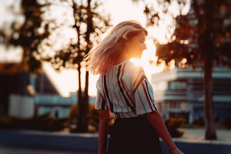Attractive blonde girl smiling at sunset. Happy Hipster lifestyleの写真素材