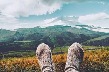 Legs in knitted gray woolen socks. Morning view on the Caucasus mountains to Elbrus. Travel lifestyle Beautiful landscapeの写真素材