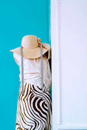 Fashion design mannequin with fabrics, measuring tape and hat. Vertical photoの写真素材