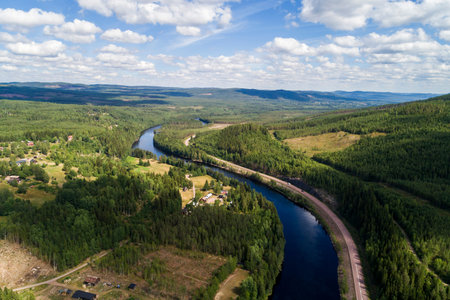 River and road running through forest and mountainous landscape ,aerial viewの写真素材