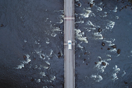 White car on bridge over river water, aerial top down viewの写真素材
