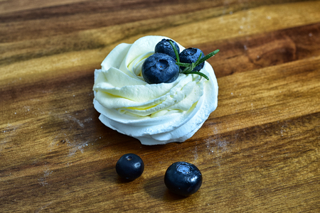 pavlova merengue dessert on wooden table. this is dessert made of round merengue and blueberry. homemade, delicious. tasty and organic. sweet dessert for any time of year and any weather.の写真素材