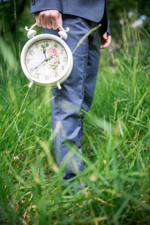 nice big alarm clock in his hand men in natureの写真素材
