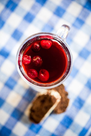 homemade cherry compote in a glass with berries
