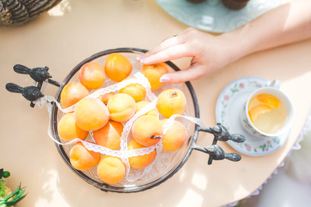 Ripe Organic Apricots on a table and the girl's handの写真素材
