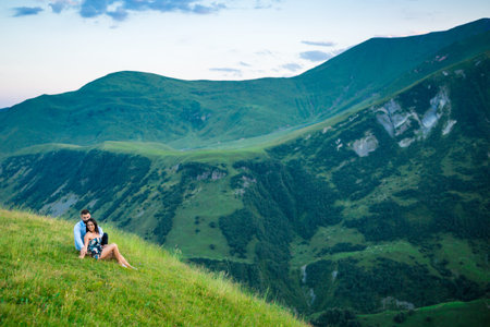 beautiful couple lying in a meadow in the mountains in springの写真素材
