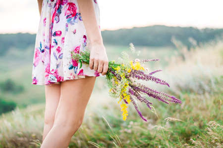 Beautiful young woman with purple flowers outdoorsの写真素材