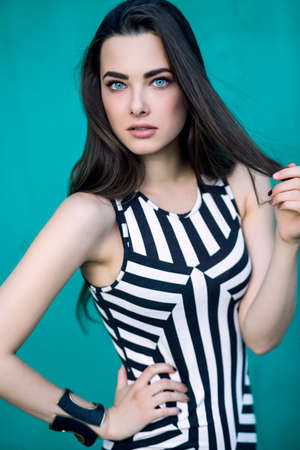 Outdoor summer portrait of young pretty cute brunette girl. Beautiful woman posing in spring.の写真素材