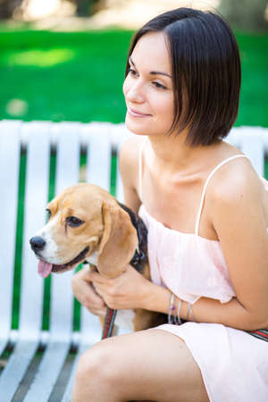 portrait of young beautiful woman with a dog outdoorsの写真素材