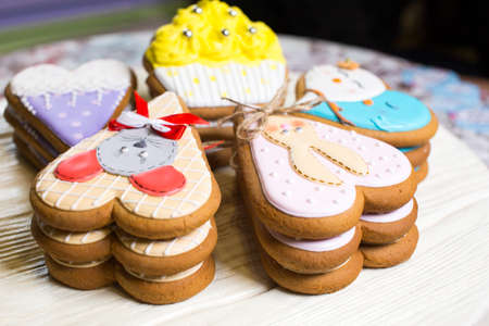 a collection of gingerbread cookies in the shape of a heart, muffins and animals on a white wooden backgroundの写真素材