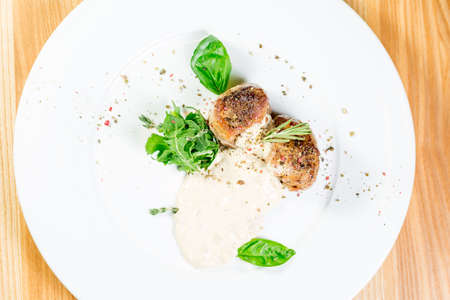 Beautiful juicy grilled meat with garnish on a wooden tableの写真素材