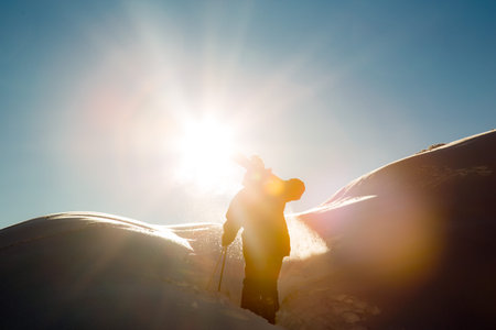 male skier carries skis in the snow on winter day at the ski resort in Georgia