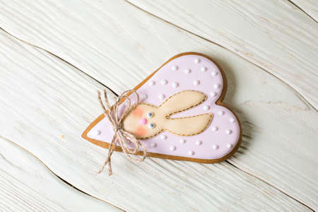 Gingerbread heart cookies with a picture of a Bunny on a wooden white backgroundの写真素材