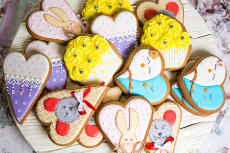 a collection of gingerbread cookies in the shape of a heart, muffins and animals on a white wooden backgroundの写真素材