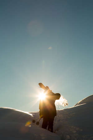 male skier carries skis in the snow on winter day at the ski resort in Georgiaの写真素材