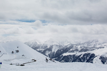 Beautiful blue skies with clouds over the mountains in the snow. Winter landscape