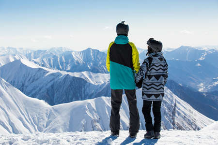 Couple in love snowboarder snowboarding on fresh white snow on ski slope on Sunny winter dayの写真素材