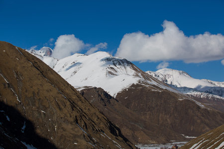Beautiful blue skies with clouds over the mountains in the snow. Winter landscape