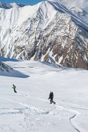Man snowboarder snowboarding on fresh white snow on ski slope on Sunny winter dayの写真素材