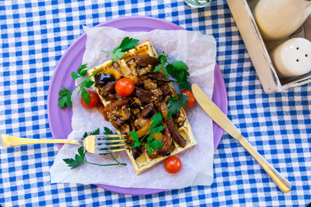 Belgian waffle with grilled mushrooms, eggplant, cherry tomatoes and parsleyの写真素材