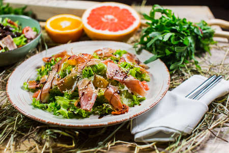 Beautiful fresh salad with lettuce, tomatoes, ham and Parmesanの写真素材