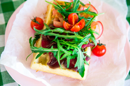 Belgian waffle with arugula, beef jerky and cherry tomatoesの写真素材