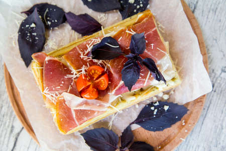 Belgian waffle with sauce, cured meat, Parmesan cheese, Basil and cherry tomatoesの写真素材