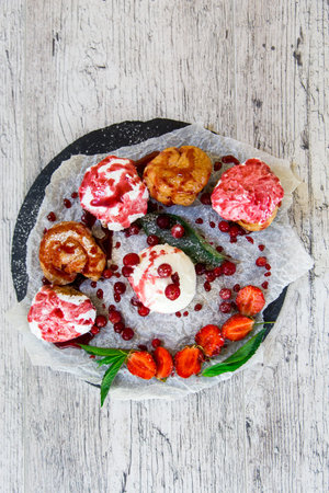 Beautiful multi-colored cakes with fresh fruit arranged on a plate