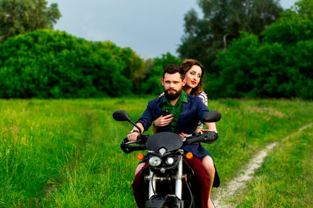 Beautiful lovers couple riding a motorcycle in nature