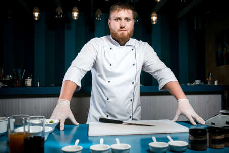 Cheerful bearded chef cook cooking preparing to work in the kitchenの写真素材