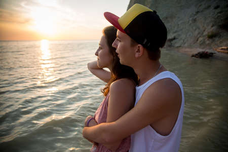 Young couple hugging at sunset in the sea. The concept of love and affection, a dateの写真素材