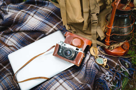 Lifestyle hiking camping equipment retro photo camera and backpack on background outdoor forest natureの写真素材