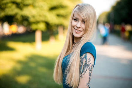 Portrait of a beautiful young blondes with long hair and cute smile outdoorsの写真素材