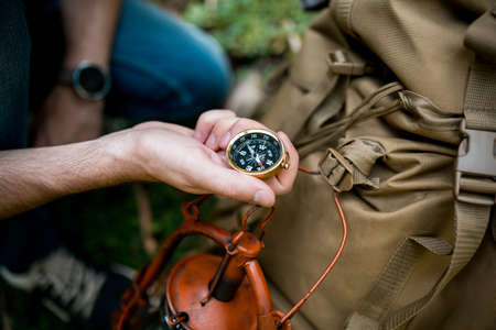 Traveler young man of searching direction with a compass in summer outdoor.の写真素材
