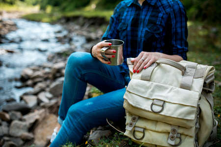 beautiful young girl tourist with backpack Hiking on the mountain riverの写真素材