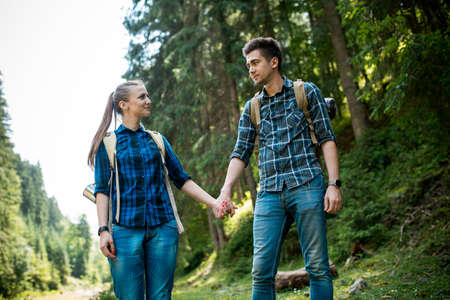 A guy and a girl tourists they go camping in the mountainsの写真素材