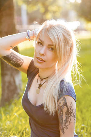 Portrait of a beautiful young blondes with long hair and cute smile outdoorsの写真素材