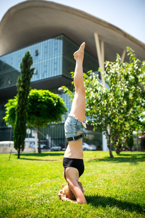 Young beautiful girl with nice body does yoga on the nature.