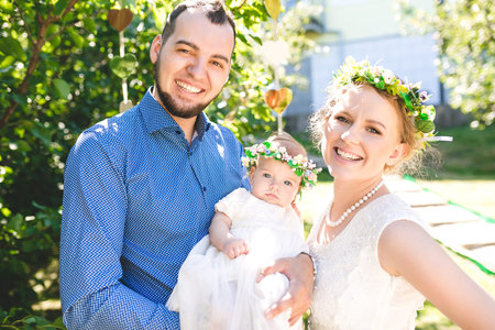 Happy joyful young family with child. Father, mother and little boy having fun outdoors in orchard...