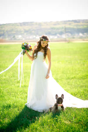 Beautiful bride in wedding dress and with a lovely mood in natureの写真素材