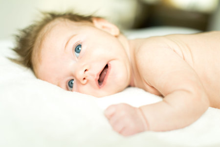 Funny and cute smiling baby looking at camera. An adorable laughing newborn girl close up.の写真素材