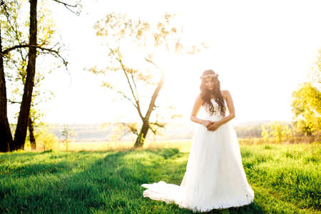 Beautiful bride in wedding dress and with a lovely mood in natureの写真素材