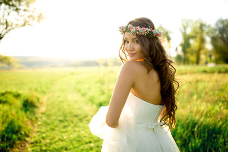 Beautiful bride in wedding dress and with a lovely mood in natureの写真素材