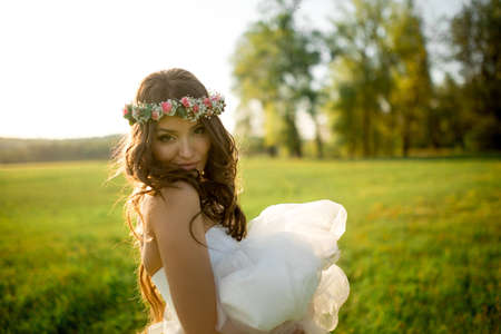 Beautiful bride in wedding dress and with a lovely mood in natureの写真素材