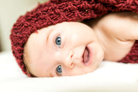 Funny and cute smiling baby looking at camera. An adorable laughing newborn girl close up.の写真素材