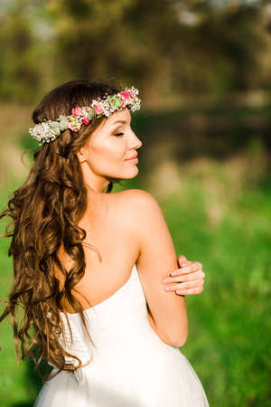 Beautiful bride in wedding dress and with a lovely mood in natureの写真素材