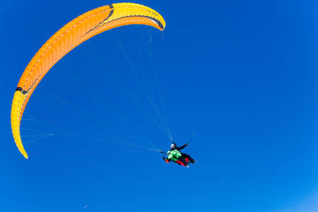 Parachute sky-diver flying in clouds above mountains. Travel adventure concept. space for textの写真素材