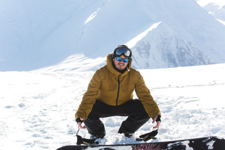 snowboarder snowboarding on fresh white snow with ski slope on Sunny winter dayの写真素材