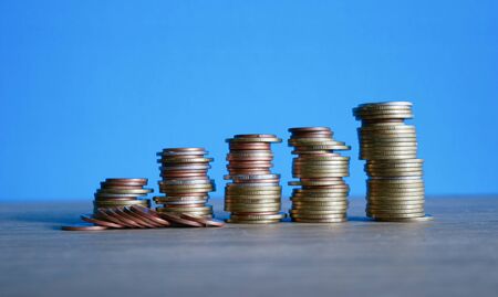 stack coins on blue background, concept business saving moneyの写真素材