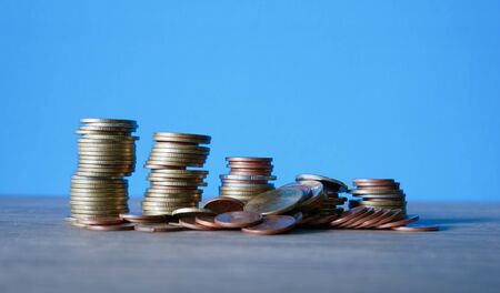stack coins on blue background, concept business saving moneyの写真素材